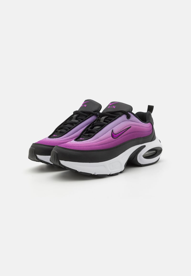 Sneakers Nike con un design sfumato viola e nero, dotati di una suola imbottita, un sistema di allacciatura audace e un'unità d'aria visibile nel tallone.