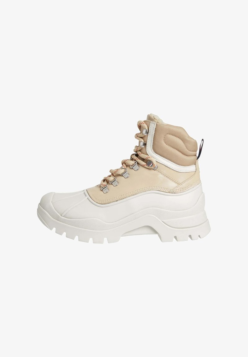 Sneaker alta con suola in gomma bianca, tomaia in tessuto beige, occhielli in metallo e allacciatura frontale. Accenti testurizzati sul colletto imbottito.