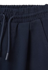 Shorts tissés bleu marine avec une taille élastique et un cordon de serrage, devant plissé et tissu lisse.