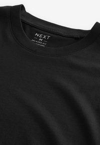 Sort T-shirt i afslappet pasform lavet af bomuld, med rund halsudskæring og blød tekstur, med et mærke der angiver brandet og plejeinstruktioner.