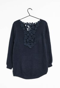 Pull bleu marine à manches longues, avec un design en dentelle florale au niveau du col. Fabriqué en tricot texturé, il possède un ourlet arrondi.