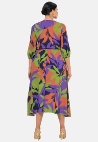 Maxikleid mit buntem Blumenmuster in Grün, Lila und Orange. Lange Ballonärmel und elastischer Bund, aus leichtem Stoff gefertigt.
