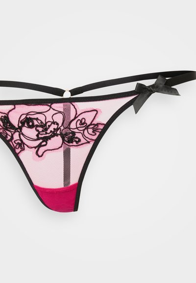 Roosa võrkmaterjalist string, millel on must lilleline tikand, musta äärisega, õhukeste rihmadega ja väikese musta paela aksessuaariga.