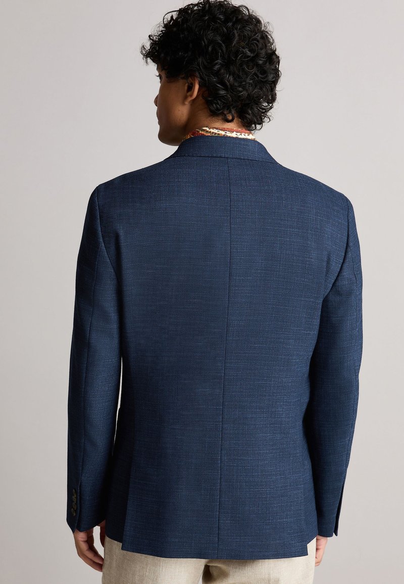 Blazer marine à motif texturé, avec une fente simple et des revers crantés. Il possède deux boutons et un détail de tissu de col contrastant.