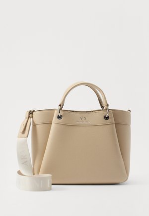 Bolso de mano de cuero beige con una forma estructurada, asas superiores, correa ajustable y un logo en la parte frontal. Texturizado, con detalles en hardware plateado.