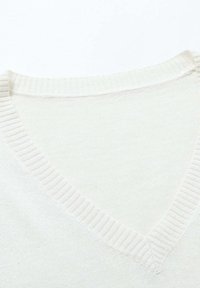 Maglione lavorato a maglia di colore crema chiaro con scollo a V. Presenta bordi a costine sul collo e sull'orlo. Texture morbida con una finitura liscia.