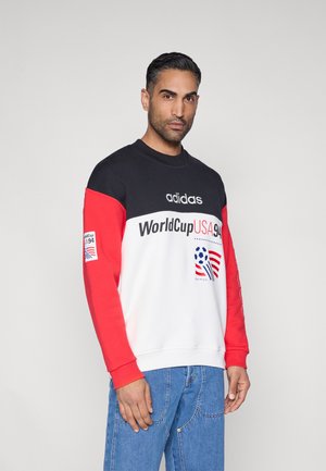 Sweatshirt mit Schwarz-, Rot- und Weißfarbblockierung. Auf der Vorderseite steht "WorldCupUSA94" und zeigt ein Logo. Gerippte Bündchen und Rundhalsausschnitt.