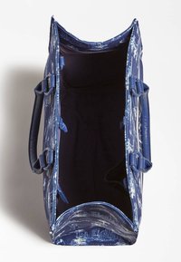 Granatowa torba z płótna o teksturowanej zewnętrznej powierzchni, z górnym zapięciem na zamek i dwoma uchwytami. Wnętrze wyłożone ciemnym materiałem, bez widocznych przegródek.