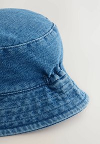 Blauer Denim-Bucket-Hut mit einer strukturierten Krone, breitem, flexiblem Rand und gerafftem Nahtdetail an der Seite.