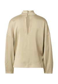 Haut beige à manches longues avec col haut et ouverture verticale en forme de goutte d'eau au dos, coupe ample, tissu doux, présenté sur fond blanc.