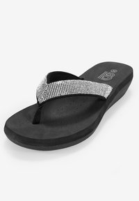 Infradito neri con suola piatta, caratterizzate da una cintura decorata con strass, texture morbida e bordatura nera decorativa per un maggior comfort.