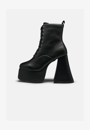 Schwarzer Plateau-Ankle-Boot mit vorderer Schnürung und breitem Blockabsatz, glatter Lederstruktur und Zuglasche hinten.