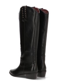Botas altas de cuero negro con un acabado suave, que presentan tachuelas decorativas en la parte superior de la parte trasera, un tacón apilado y una punta redondeada.