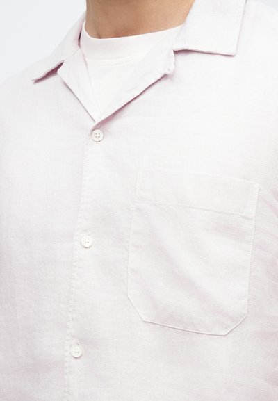 Ανοιχτό ροζ πουκάμισο από λινό με κοντό μανίκι, με μυτερό γιακά, κουμπωτή πατιλέτα και μία τσέπη στο στήθος. Μαλακή υφή και άνετη, casual εφαρμογή.