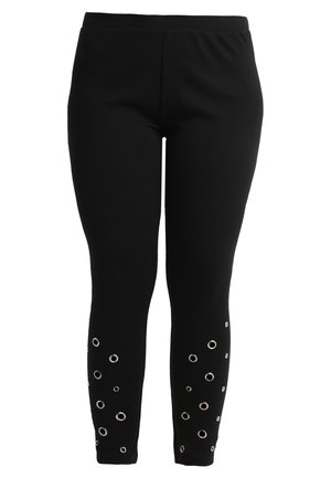 Leggings neri realizzati in un materiale elastico, con ritagli circolari e occhielli in metallo lungo la gamba per dettagli decorativi.