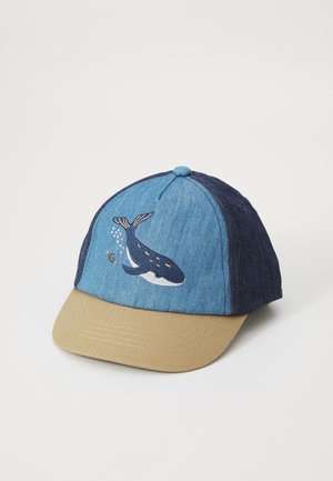 Gorra de denim azul con visera beige que presenta un diseño de ballena bordado en la parte frontal. Incluye un botón central y paneles contrastantes.