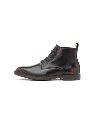 Stivaletto da uomo in pelle marrone scuro con chiusura stringata frontale, linguetta sul tallone e suola bassa piatta in gomma su sfondo bianco.