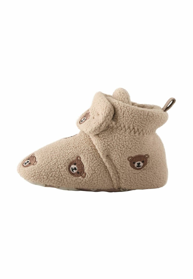 Chausson bébé beige doux avec des visages d'ours brodés, texture en polaire, et une sangle ajustable avec un détail nounours sur le côté.