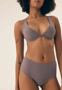 Mauve ribbed bikini top with a deep V-neck and wide straps, paired with high-waisted bottoms featuring a scalloped edge.