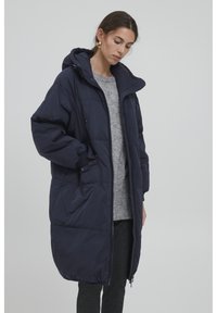 Námorná puffa bunda s kapucňou, so zipsom vpredu, bočnými vreckami a dĺžkou po kolená, vyrobená z hladkého izolovaného materiálu.