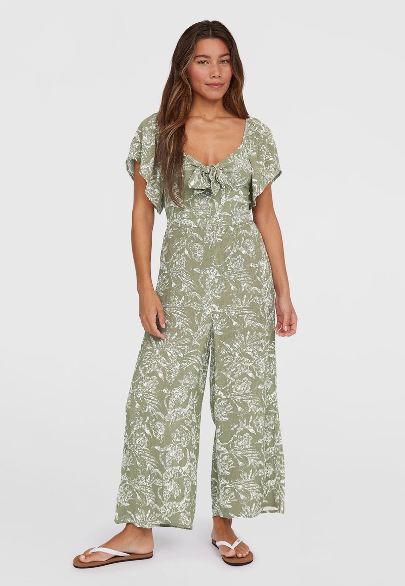 Jumpsuit vert clair avec de courtes manches volantes, un détail de nouage à l'avant, un motif floral blanc, des jambes larges et un tissu texturé.