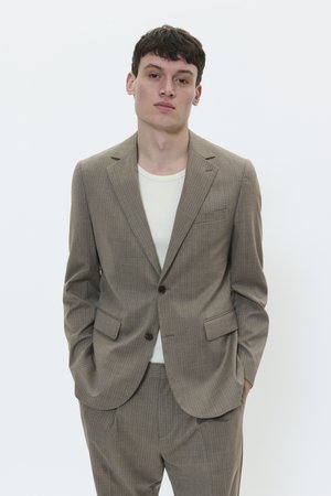Brown pinstriped suit, fitted with notched lapels, two front pockets, and a single button closure. Worn over a light-colored shirt.