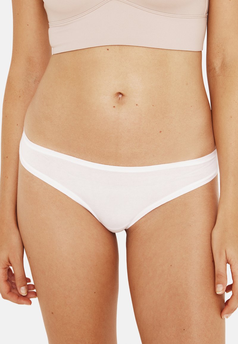 Culotte de bikini en coton blanc avec une texture lisse et extensible et un design taille basse. Présente une ceinture élastique contrastante.