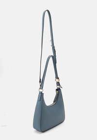 Μπλέ δερμάτινη τσάντα ώμου με καμπυλωτό σχήμα, ρυθμιζόμενο λουρί, χρυσά αξεσουάρ και άνοιγμα με φερμουάρ. Λείο υλικό με ελάχιστες λεπτομέρειες.