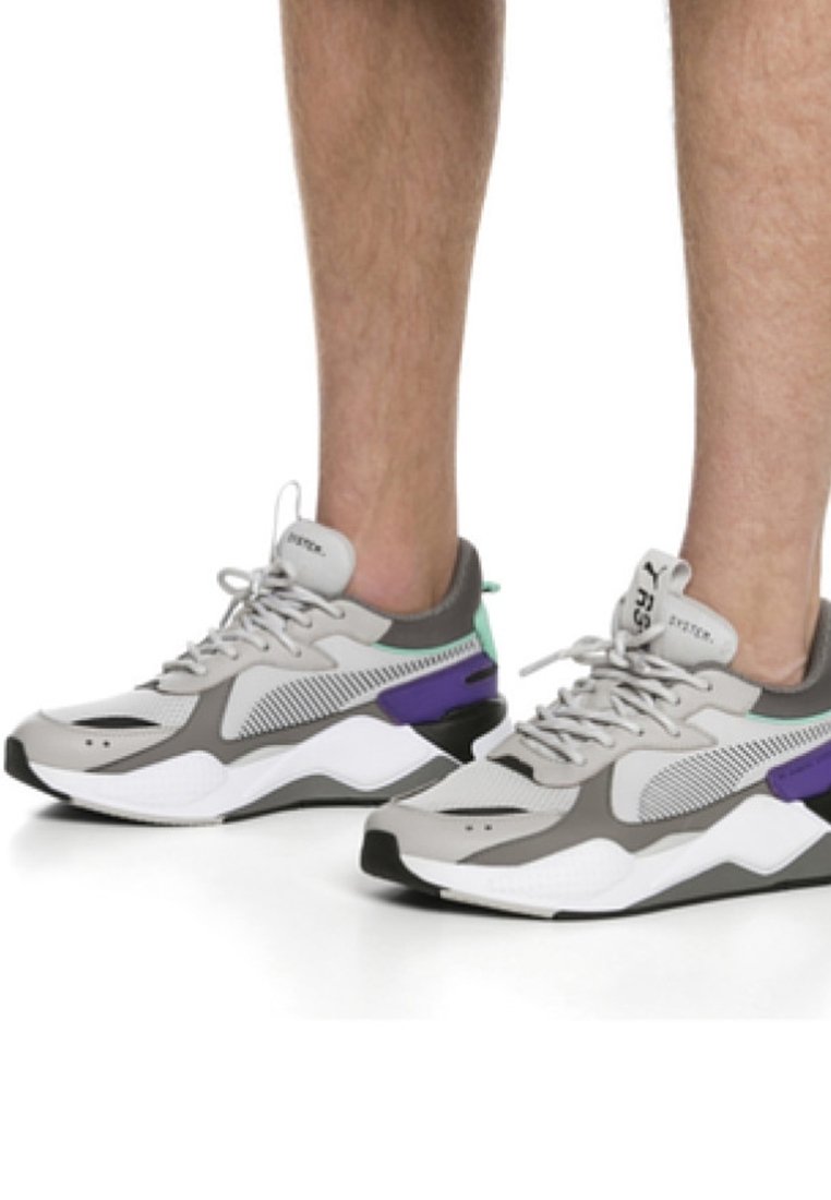 Scarpe sportive grigie con tomaia in rete, con accenti viola e verdi, un collare imbottito e una suola bianca spessa.