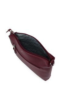 Burgundská kožená taška se zipovým uzávěrem, s hladkým povrchem a vzorovaným šedým interiérem. Obsahuje malou boční kapsu se zipem.