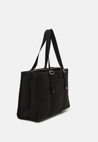 Sort nylon taske med dobbelt stropper, lynlåslukning, en forlomme og plisserede sider. Har metallic hardware-detaljer.