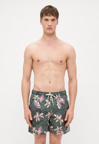 Virágmintás fürdőshorts, sötétzöld alapú, rózsaszín és fehér növényi mintákkal, rugalmas derékrésszel és húzózsinórral.