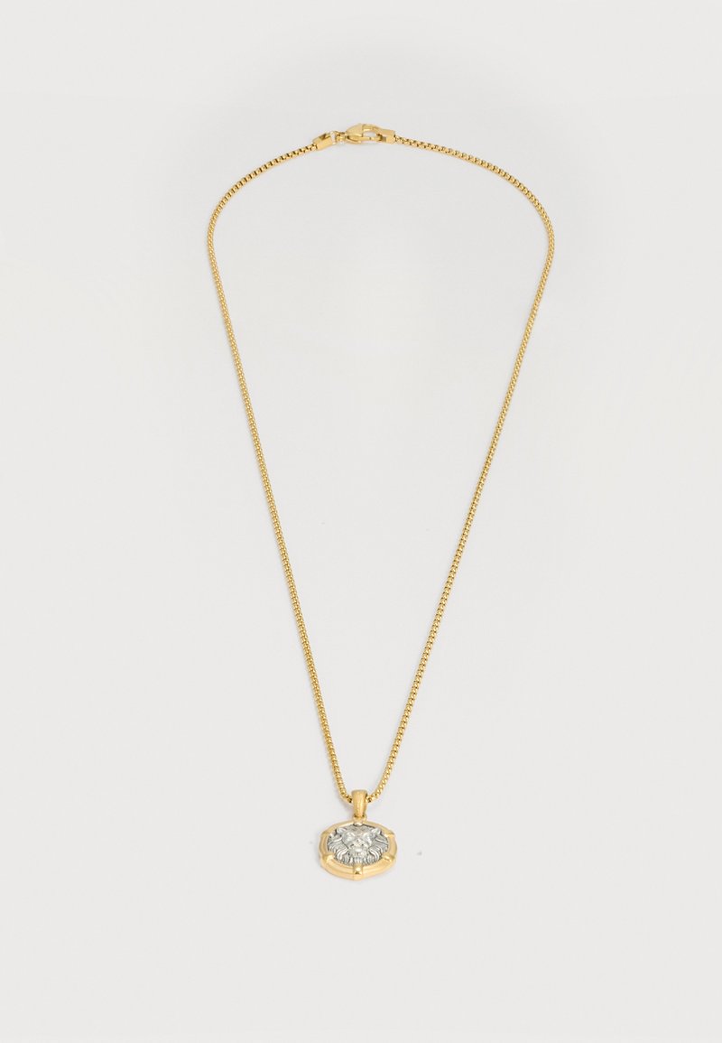 Goldkette mit rundem Anhänger, der ein detailliertes silbernes Löwenkopf-Design zeigt.