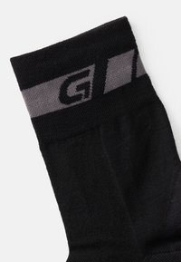 Calzini neri con una fascia a righe grigie nella parte superiore, realizzati in un tessuto liscio e strutturato e caratterizzati da un design semplice e funzionale.