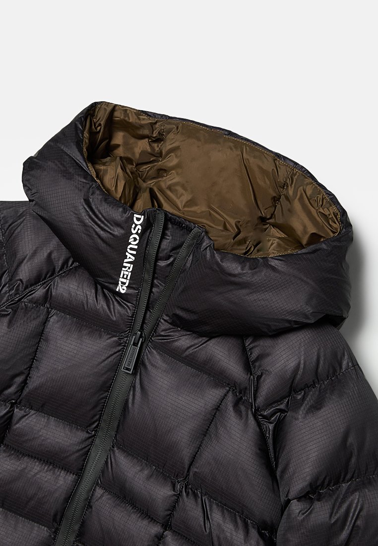 Giacca imbottita nera con colletto alto e chiusura con zip. Presenta una consistenza lucida con un interno marrone e un dettaglio con marchio sul collo.