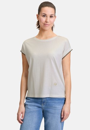 T-shirt gris clair à manches courtes avec un col rond, mettant en avant des accents noirs sur les manches et un petit motif brodé près de l'ourlet.