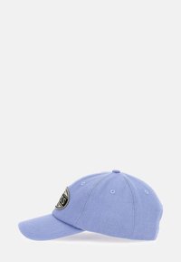 Lichtblauwe baseballpet met een gebogen klep en een ronde beige-zwart patch-logo aan de voorkant.