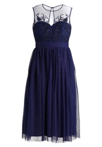 Laivastonsininen mekko, jossa on vartalonmyötäinen yläosa, jossa on kukka-aiheista kirjailua ja helmiripauksia; läpikuultava päällyskerros ja liehuva tyllihame.