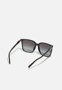 Black sunglasses with gradient gray lenses, square frame design, and sleek, glossy finish. Features gold hardware on the temples.