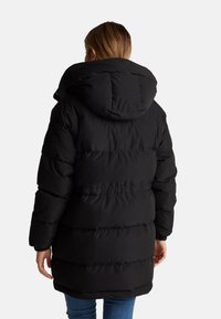 Černá péřová bunda s kapucí, prošívaný design a objemný vzhled, s elastickými manžetami a stahovacím pasem pro zvýšení tepla.