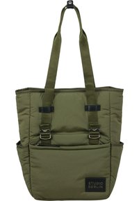 Tote bag olivinvihreästä pehmustetusta kankaasta, jossa on kaksi yläkahvaa, säädettävät hihnat ja edessä vetoketjullinen tasku, jossa on brändilogo.
