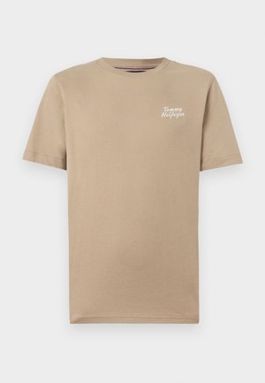 T-shirt beige in cotone a maniche corte con il logo "Tommy Hilfiger" in scritta bianca sul petto a sinistra.
