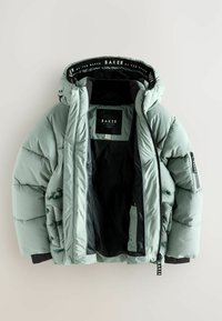 Lichtgroene gewatteerde winterjas met zwarte voering, ritssluiting aan de voorkant en mouwen, en "Baker by Ted Baker" branding op de kraag en rits.