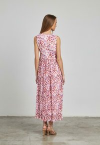 Abito maxi floreale in tonalità di rosa e viola, design senza maniche, corpino aderente con vita arricciata, gonna fluida e morbida texture del tessuto.