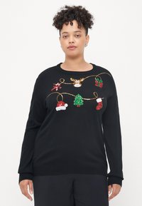 Pulover negru cu decorațiuni colorate din mărgele: reni, pălării de Moș Crăciun, un brad de Crăciun și bastonașe de zahăr pe un fir aurie. Gât rotund, mâneci lungi.