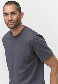 Grå bomulds t-shirt med klassisk rund hals, korte ærmer, glat tekstur og tætsiddende silhuet. Ingen synlige mønstre eller grafik.