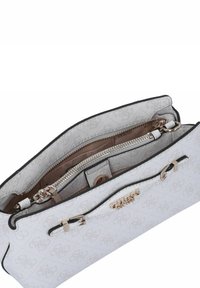 Borsa bianca con superficie texturizzata, accessori in oro, chiusura con zip e tasca interna; presenta un motivo sottile e dettagli in nero.