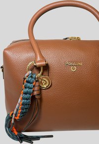 Borsa a mano in pelle marrone con finiture dorate, superficie testurizzata e portachiavi decorativo con dettagli intrecciati in blu, arancione e grigio.