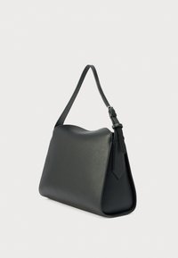 Geantă de mână din piele neagră, cu o formă trapezoidală structurată. Dispune de o singură curea ajustabilă și o textură netedă, cu un luciu subtil.