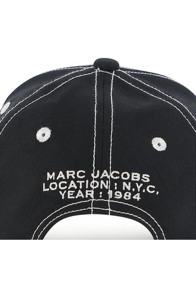 Μαύρο καπέλο μπέι ζμπολ με λευκή ραφή. Διαθέτει κέντημα στο πίσω μέρος: "MARC JACOBS, ΤΟΠΟΘΕΣΙΑ: NYC, ΕΤΟΣ: 1984."